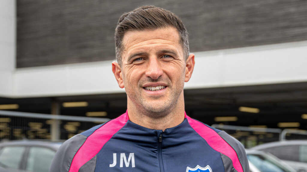 Portsmouth boss John Mousinho smiling.