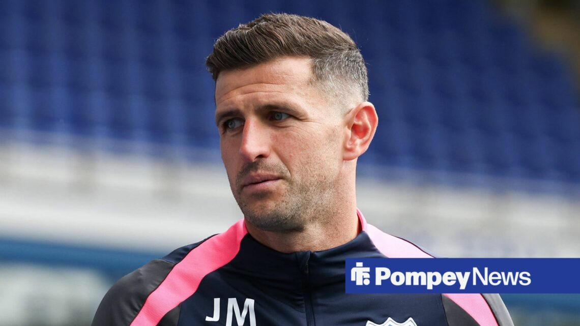 John Mousinho wearing Portsmouth jumper in stadium