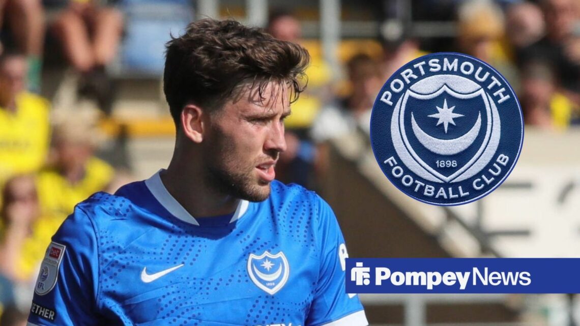 Callum Lang looking at Portsmouth badge in circle